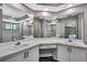 Bathroom featuring a dual sink vanity, large mirrors, and a glass shower with a view of the pool at 11379 Flower Ave, Weeki Wachee, FL 34613