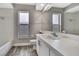 Bathroom featuring gray walls, a window, white cabinets, and a vanity with chrome hardware at 11379 Flower Ave, Weeki Wachee, FL 34613