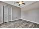 Bedroom featuring gray walls, wood look flooring, a ceiling fan, and a closet with shuttered doors at 11379 Flower Ave, Weeki Wachee, FL 34613