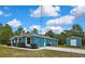 Blue home featuring a side yard, long driveway and detached shed at 11379 Flower Ave, Weeki Wachee, FL 34613