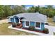 Blue single story house featuring well-manicured landscaping, updated roof, and a quaint shed at 11379 Flower Ave, Weeki Wachee, FL 34613