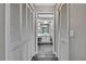 Hallway with closet space leads into a bathroom with a vanity and gray wood-look flooring at 11379 Flower Ave, Weeki Wachee, FL 34613