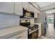 Modern kitchen with stainless steel appliances, white cabinets, and sleek countertops at 11379 Flower Ave, Weeki Wachee, FL 34613