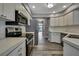 Modern kitchen features stainless steel appliances, white cabinetry, and wood-look tile flooring at 11379 Flower Ave, Weeki Wachee, FL 34613