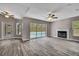 Open living space features a fireplace, sliding doors to the lanai, and wood-look flooring at 11379 Flower Ave, Weeki Wachee, FL 34613