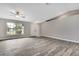 Bright living room with wood-look tile flooring, a ceiling fan, and a large window that provides natural light at 11379 Flower Ave, Weeki Wachee, FL 34613