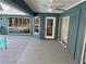 View of the pool patio with ceiling fan and access to the pool through sliding glass doors and a screen enclosure at 11379 Flower Ave, Weeki Wachee, FL 34613