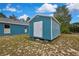 A cozy blue shed stands next to the home, providing great backyard storage space at 11379 Flower Ave, Weeki Wachee, FL 34613