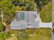 Aerial view of a beautifully landscaped home with a screened-in pool and lush green yard at 1156 Battersea Ave, Spring Hill, FL 34609