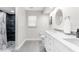 Bright bathroom featuring a double vanity, tile flooring, and a walk-in shower at 1156 Battersea Ave, Spring Hill, FL 34609