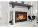Close-up of a stone fireplace with lit fire and stylish accessories at 1156 Battersea Ave, Spring Hill, FL 34609