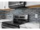 A modern kitchen showcases stainless steel appliances and a stylish backsplash at 1156 Battersea Ave, Spring Hill, FL 34609