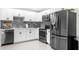A well-lit kitchen featuring modern stainless steel appliances and white cabinets at 1156 Battersea Ave, Spring Hill, FL 34609