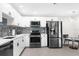 Modern kitchen with white cabinetry, stainless steel appliances, and a tile backsplash at 1156 Battersea Ave, Spring Hill, FL 34609