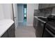 Laundry room features gray cabinets, white countertop, tiled backsplash, and modern washer and dryer at 1156 Battersea Ave, Spring Hill, FL 34609