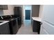 Well-equipped laundry room with gray cabinets, white countertops, and modern washer and dryer at 1156 Battersea Ave, Spring Hill, FL 34609