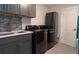 Modern laundry room featuring gray cabinetry, sink, and new washer and dryer at 1156 Battersea Ave, Spring Hill, FL 34609