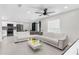Bright, open living space with a modern ceiling fan and a spacious white sectional sofa, adjacent to the kitchen at 1156 Battersea Ave, Spring Hill, FL 34609