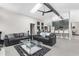 Open living room with gray sofas, modern glass coffee table, and a sleek ceiling fan at 1156 Battersea Ave, Spring Hill, FL 34609