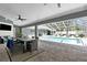 Covered outdoor living space featuring a ceiling fan, outdoor furniture, television, and stunning pool view at 1156 Battersea Ave, Spring Hill, FL 34609