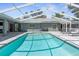 Inviting backyard pool with a screened enclosure, complemented by lounge chairs and a well-maintained patio area at 1156 Battersea Ave, Spring Hill, FL 34609