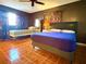 This spacious bedroom showcases a ceiling fan, dark walls, and warm-toned, wood-look flooring at 12037 Boynton Ln, New Port Richey, FL 34654