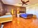 Spacious bedroom featuring wood-patterned flooring, a ceiling fan, and two comfortable beds at 12037 Boynton Ln, New Port Richey, FL 34654