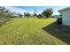 Expansive front yard featuring lush green grass and minimal landscaping for a tidy look at 12037 Boynton Ln, New Port Richey, FL 34654