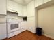 Bright kitchen with white cabinets, tiled floors, and appliances at 12037 Boynton Ln, New Port Richey, FL 34654