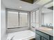 A bathroom featuring a soaking tub with faucet and two large windows with coverings at 12087 Tallwood St, Spring Hill, FL 34608