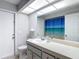 Clean bathroom featuring tile floors, a large mirror, and white accents at 12087 Tallwood St, Spring Hill, FL 34608