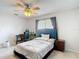 Well-lit bedroom featuring tile floors, natural lighting, ceiling fan, and desk area at 12087 Tallwood St, Spring Hill, FL 34608