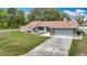 Charming single-story home featuring a well-manicured lawn and an attached two-car garage at 12087 Tallwood St, Spring Hill, FL 34608
