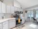 Bright kitchen showcasing modern appliances and white cabinets, adjacent to an eat-in dining area at 12087 Tallwood St, Spring Hill, FL 34608