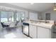 Modern kitchen area with stainless steel dishwasher and white countertops, adjacent to dining space at 12087 Tallwood St, Spring Hill, FL 34608