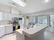Bright kitchen featuring stainless steel appliances, white cabinets, and a breakfast bar at 12087 Tallwood St, Spring Hill, FL 34608