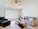 Bright living room with neutral tones, wood-look flooring, ceiling fan, and comfortable seating at 12087 Tallwood St, Spring Hill, FL 34608