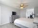 The main bedroom features a ceiling fan, neutral walls, and a dresser with a television on top at 12087 Tallwood St, Spring Hill, FL 34608
