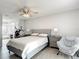 This stylish main bedroom offers lots of natural light and a seating area with comfortable chair at 12087 Tallwood St, Spring Hill, FL 34608