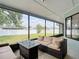 Screened patio features a comfortable sofa, a glass table, and a view of the backyard at 12087 Tallwood St, Spring Hill, FL 34608