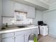 Outdoor kitchen with gray cabinets and tiled backsplash at 12087 Tallwood St, Spring Hill, FL 34608