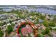 Aerial view of home featuring a screened-in pool, located within a lakeside community surrounded by lush greenery at 1218 Castle Ter, Tarpon Springs, FL 34689
