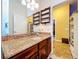 The modern bathroom features a granite-topped vanity and large mirror plus a view into another room at 1218 Castle Ter, Tarpon Springs, FL 34689