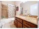 Bathroom with granite countertops, wood cabinets, a tub, and a shower at 1218 Castle Ter, Tarpon Springs, FL 34689