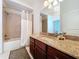 The bathroom features a shower over bath, a granite-topped vanity and large mirror at 1218 Castle Ter, Tarpon Springs, FL 34689