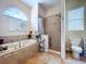 Bright bathroom with jacuzzi tub, tiled shower, neutral paint, and arched window at 1218 Castle Ter, Tarpon Springs, FL 34689
