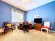 Bright bedroom features blue walls, a ceiling fan, a window, and a comfortable desk space with two comfy chairs at 1218 Castle Ter, Tarpon Springs, FL 34689