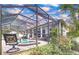 Enjoy outdoor living with a screened-in pool, brick patio, spa, and lush landscaping for relaxing and entertaining at 1218 Castle Ter, Tarpon Springs, FL 34689