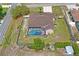 Aerial view showcasing a private backyard with screened lanai, swimming pool, and fenced yard at 12300 Drake Ln, Spring Hill, FL 34609