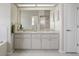 Bathroom featuring double sinks with a large mirror and white cabinets for ample storage at 12300 Drake Ln, Spring Hill, FL 34609